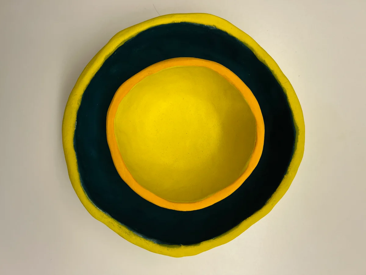 The original overhead photograph used in Bookends: a small yellow bowl nested inside a larger dark green bowl with a yellow rim.